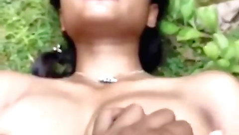 Indian brunette is playing with her boobs and ass outdoors